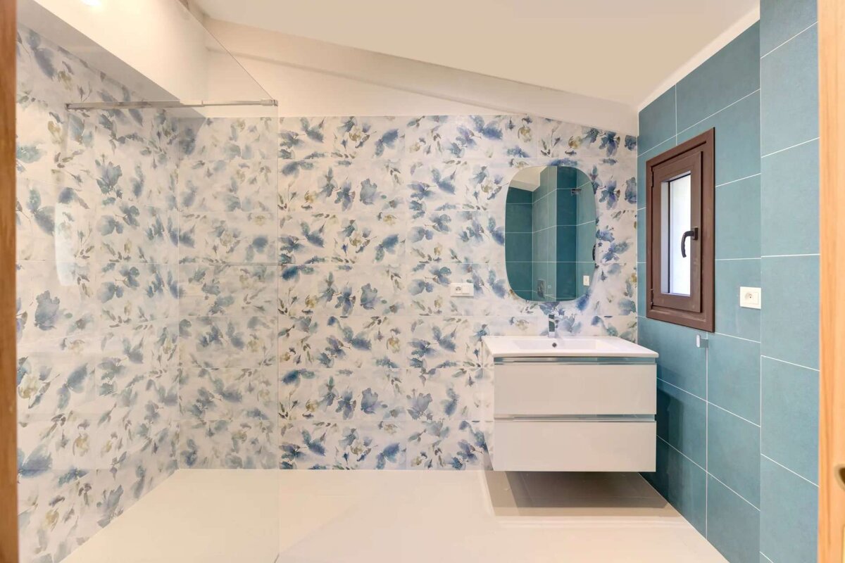 A bathroom with blue and white tiles and a sink