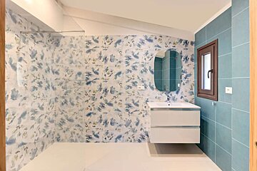 A bathroom with blue and white tiles and a sink