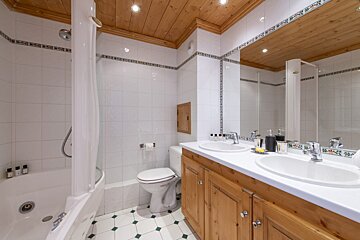 A bathroom with two sinks a toilet and a bathtub