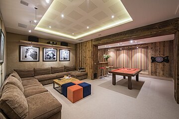 A game room with a pool table and a dart board