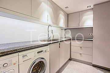 A kitchen with a miele washing machine and a sink