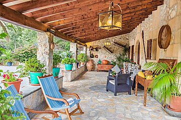 A porch with rocking chairs and potted plants