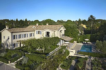 A large house with a swimming pool in front of it