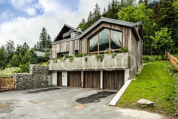 A large house with a lot of windows is surrounded by trees