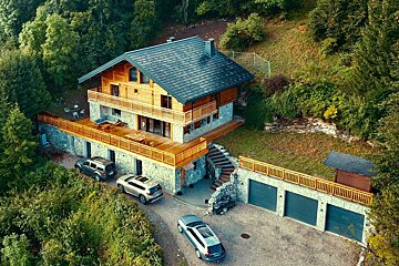 A volvo suv is parked in front of a large house