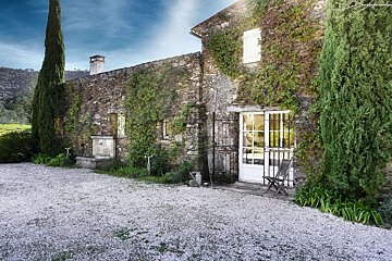 A stone building with a white door and white shutters
