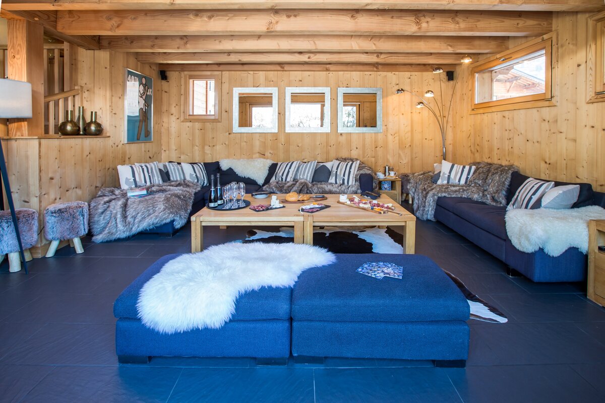 A living room with a blue couch and a blue ottoman