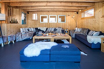 A living room with a blue couch and a blue ottoman
