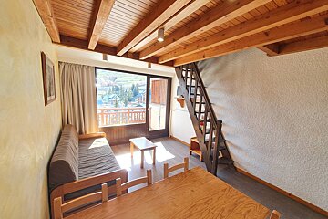A living room with a staircase leading up to the second floor