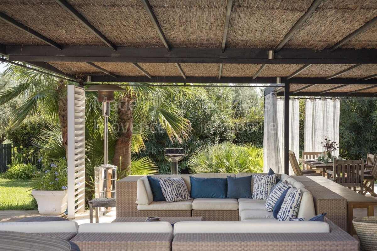 A patio with a sectional couch under a roof that says provence immobilier