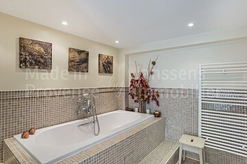 A bathtub in a bathroom with a sign that says made in