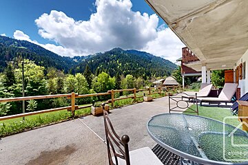A table and chairs on a patio with mountains in the background