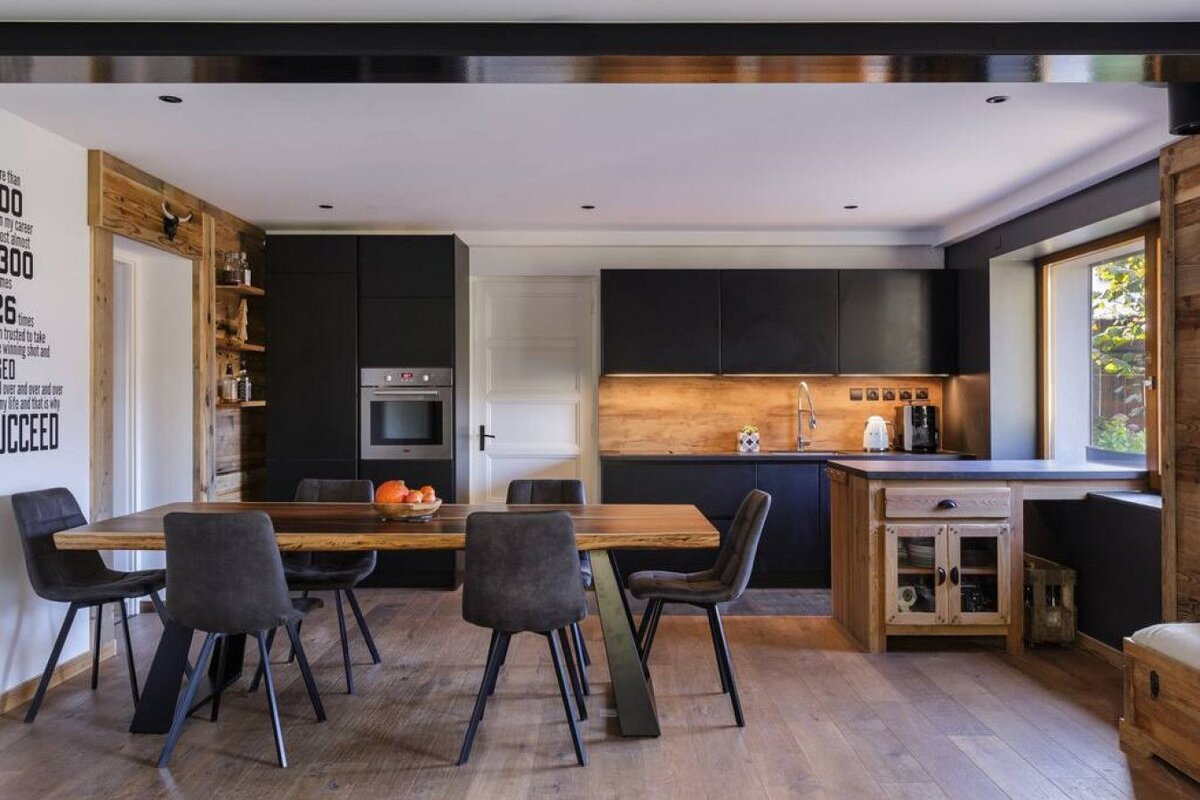 A kitchen with black cabinets and a sign on the wall that says succeed