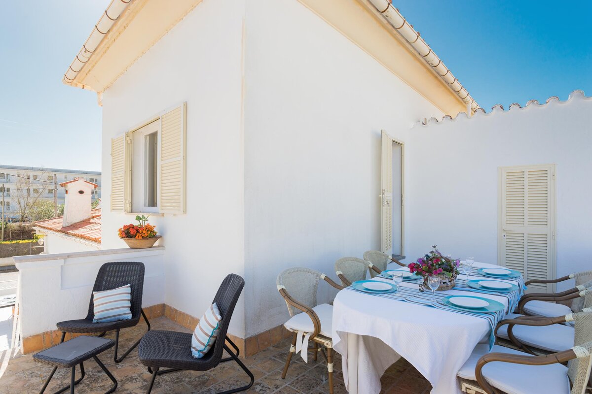 A white house with a table and chairs in front of it