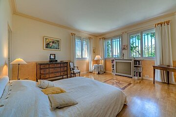 A bedroom with a large bed and a dresser