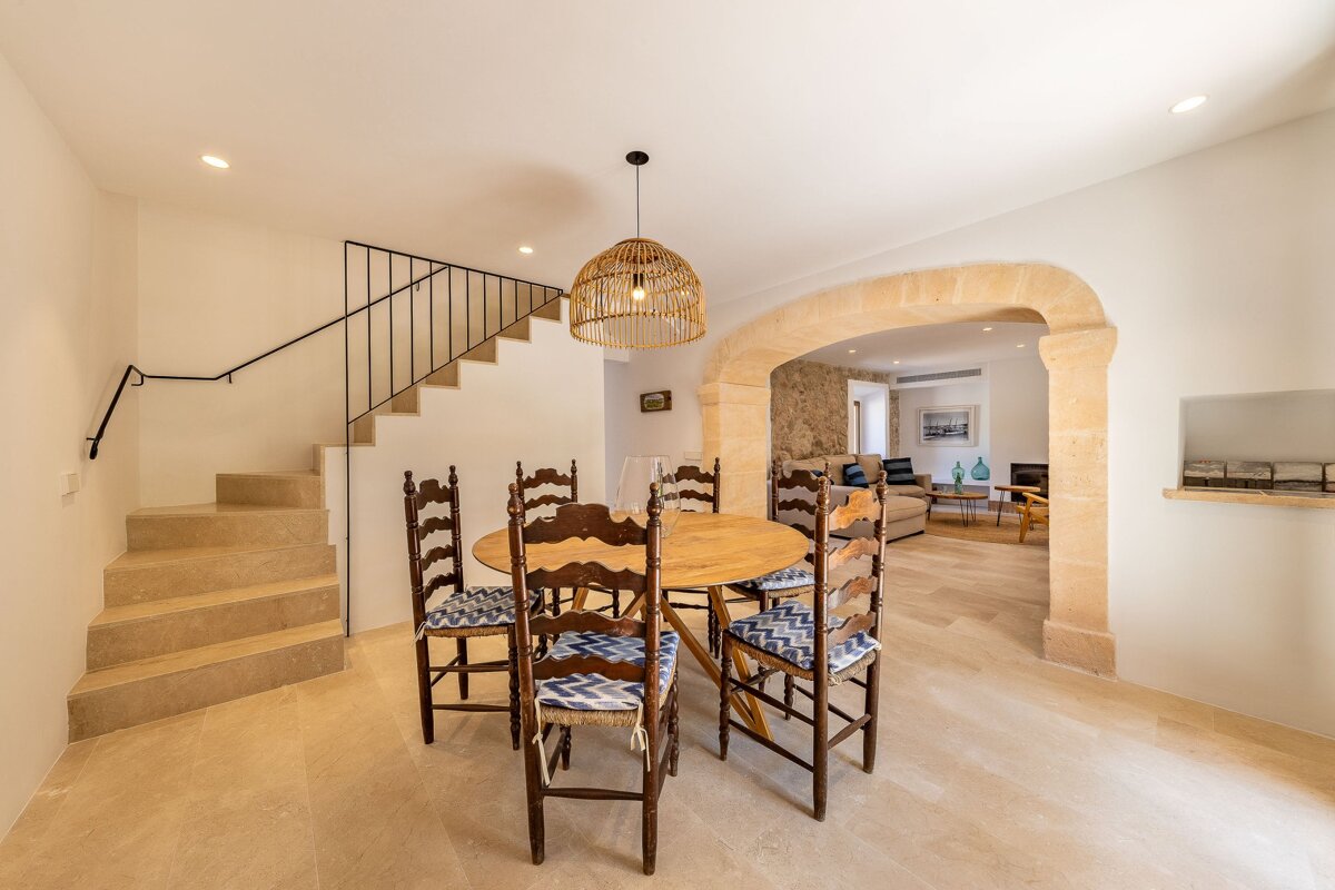 A dining room with a table and chairs and stairs