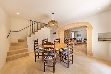 A dining room with a table and chairs and stairs
