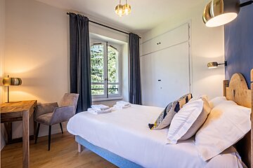 A bedroom with a large bed and a window