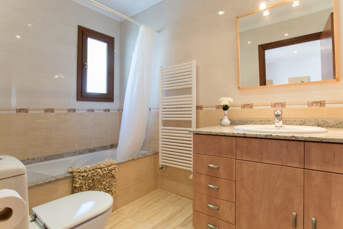 A bathroom with a toilet a sink and a window