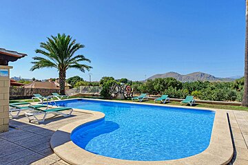 A large swimming pool surrounded by chairs and palm trees