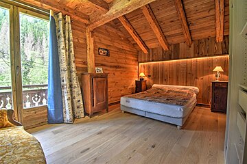 A wooden bedroom with a bed and a window