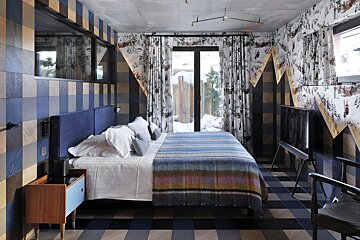 A bedroom with a large bed and a striped blanket