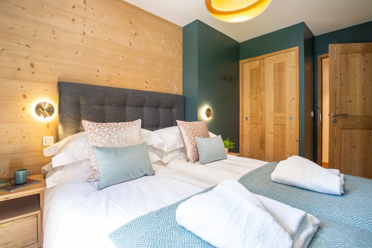 A bedroom with a large bed and a wooden wall