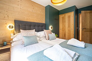 A bedroom with a large bed and a wooden wall