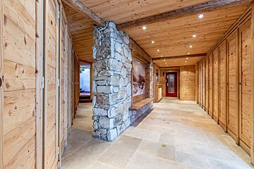 A hallway with wooden walls and a stone wall