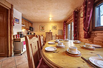 A dining room table with plates and cups on it