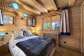A bed in a wooden room with the word alpine on it