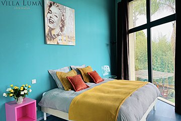 A bedroom with a bed and a painting on the wall that says villa luma