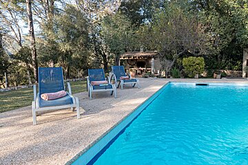 A swimming pool surrounded by chairs with towels on them