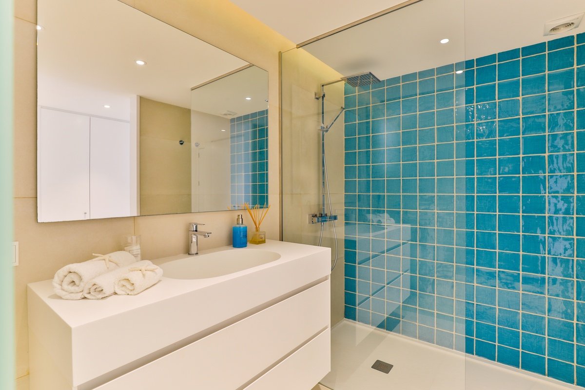 A bathroom with blue tiles and a sink