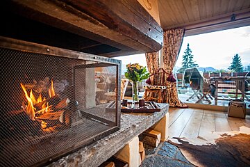A fireplace in a living room with a view of the mountains