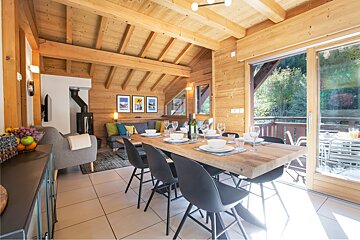 A dining room table with a bottle of wine on it