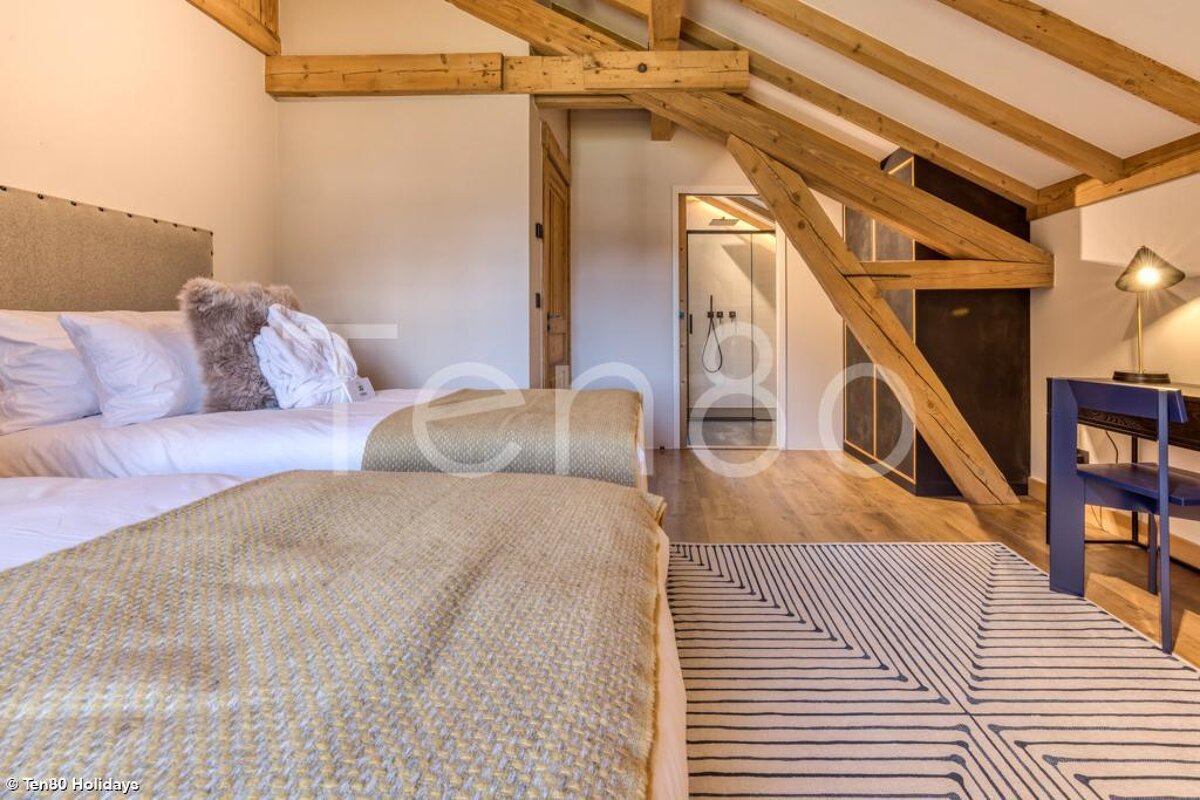 A bedroom with two beds and a rug that says ten80 holidays