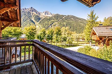 A balcony with a view of mountains and trees
