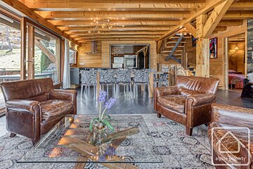 A living room with two leather chairs and a glass coffee table that says alpine property