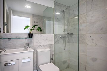 A bathroom with a toilet a sink and a mirror