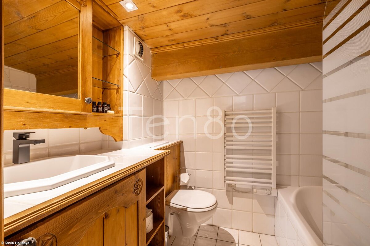 A bathroom with a toilet a sink and a towel rack