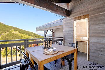 A table and chairs on a balcony with rental designer written on the bottom right