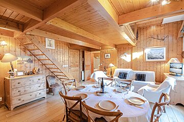 A wooden living room with a dining table and chairs
