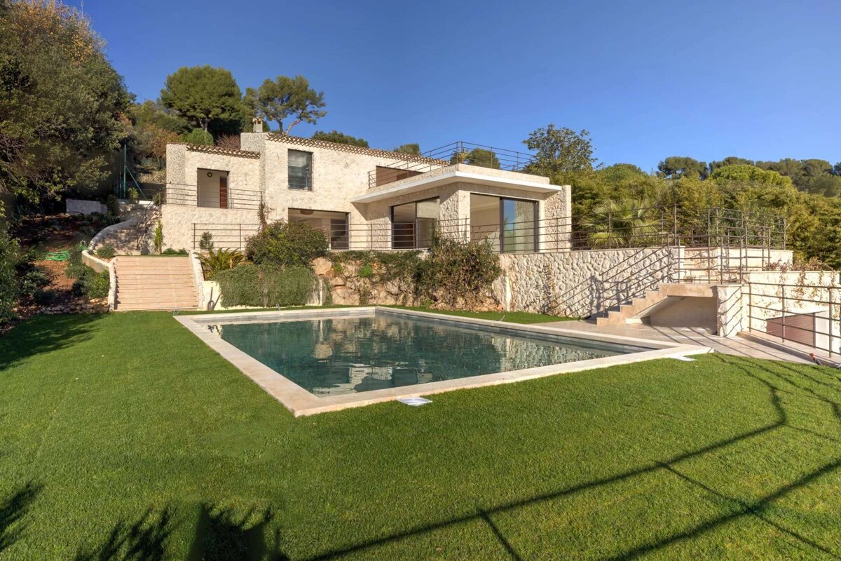 A house with a large swimming pool in front of it