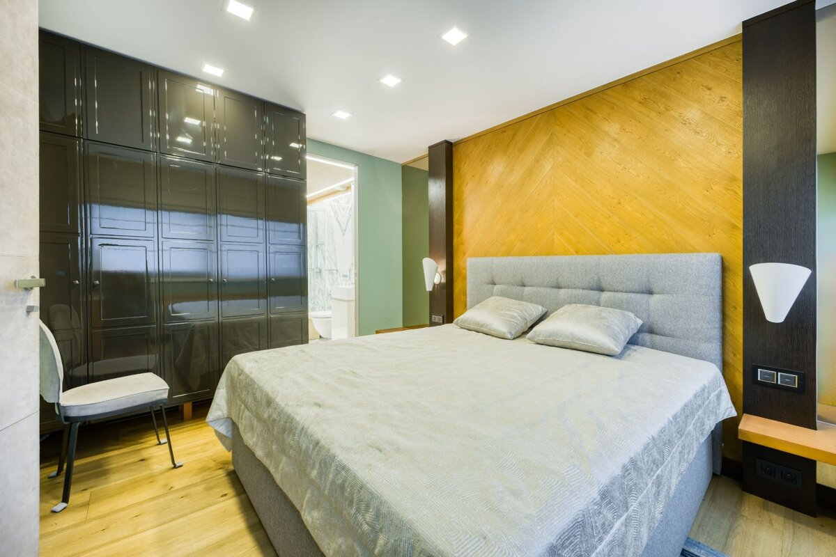 A bedroom with a large bed and a chair