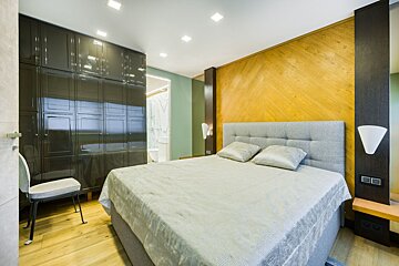 A bedroom with a large bed and a chair