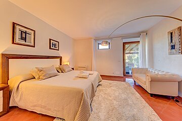 A bedroom with a large bed and a couch