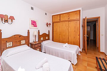 A bedroom with two beds and a picture of a flower on the wall