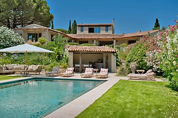 A large house with a swimming pool in front of it