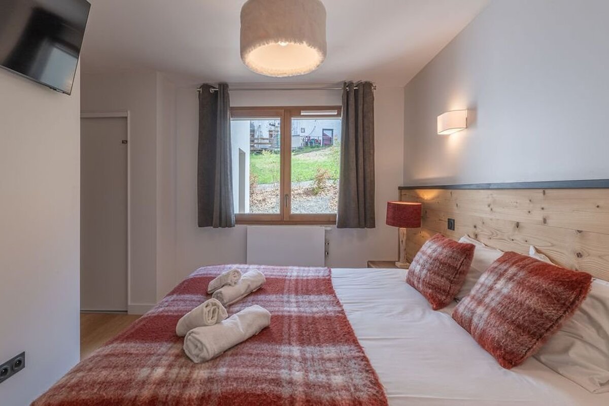 A bedroom with a large bed and a window